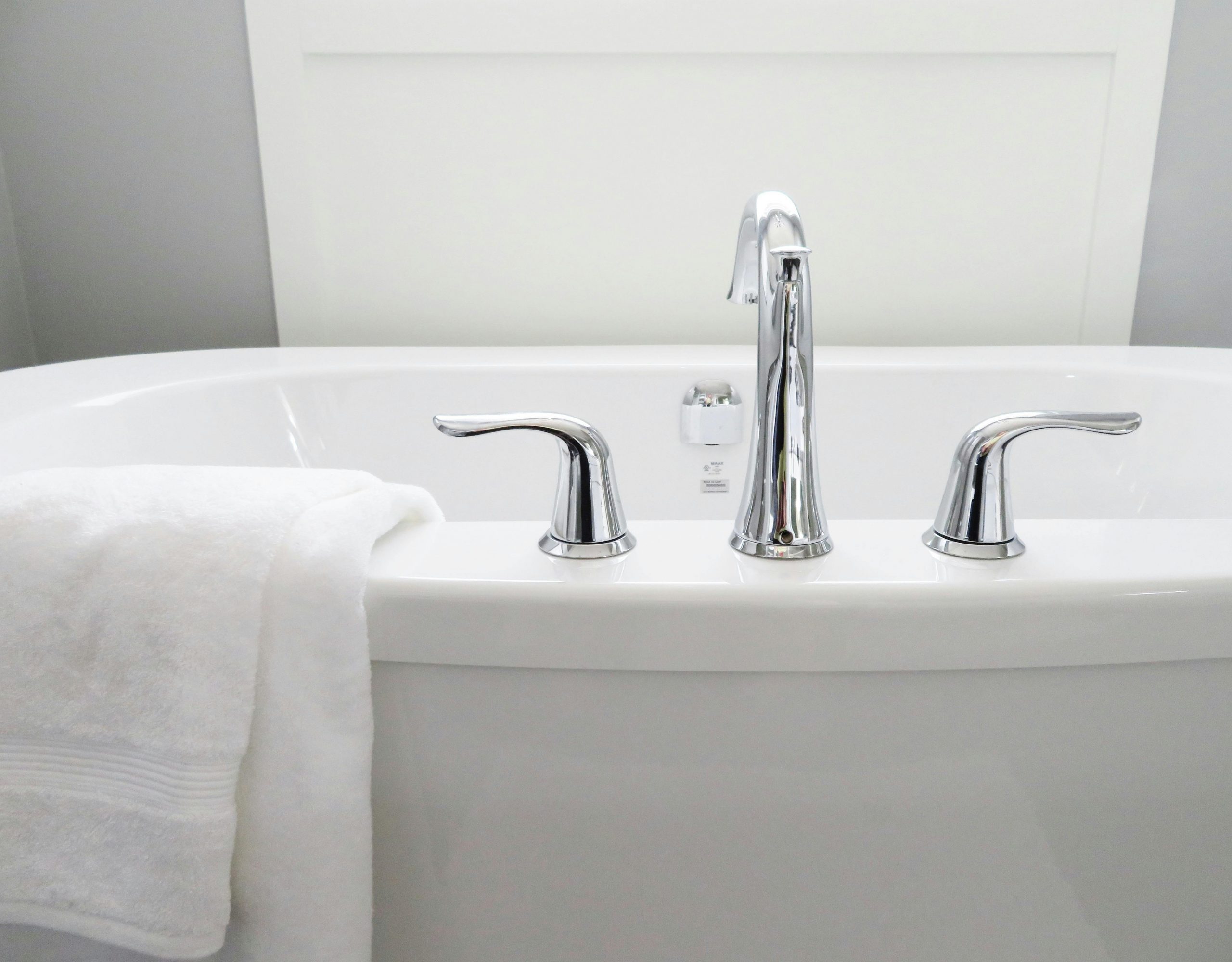 porcelain bathtub with a white towel draped over the edge
