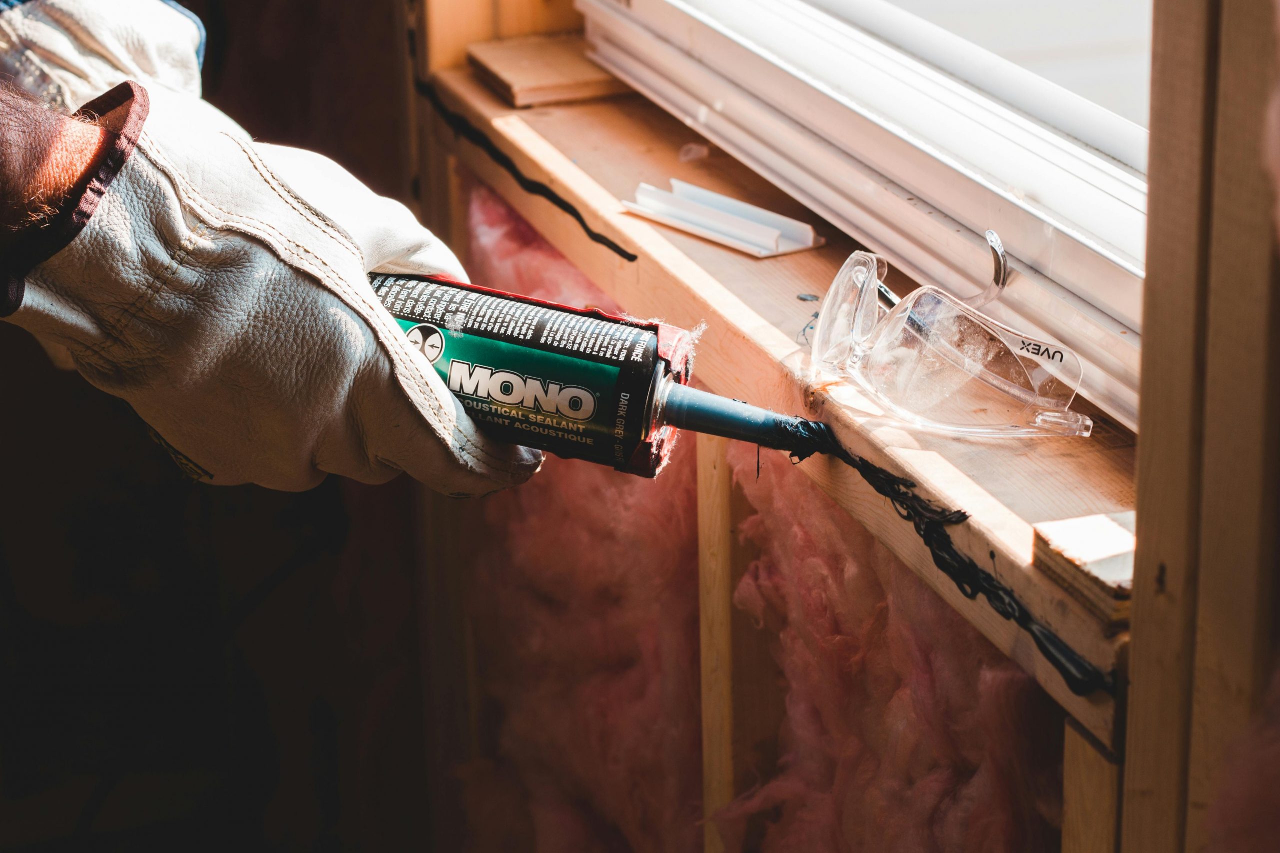 person applying sealant to a window seam